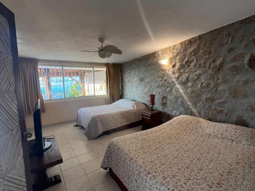 a hotel room with two beds and a window at Villa de descanso in Acapulco