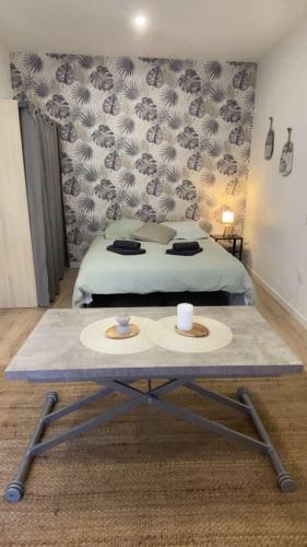 a bedroom with a bed and a table with two hats on it at Studio Cosy - proche du centre ville in Guingamp