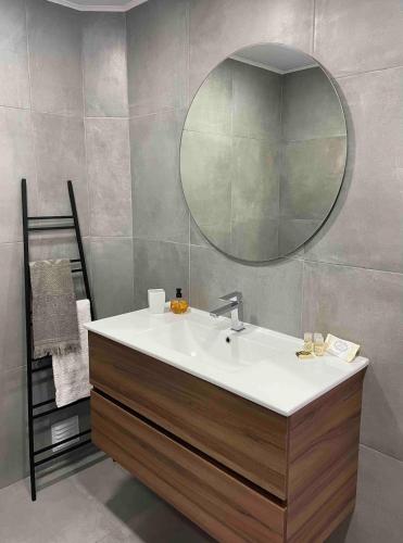 a bathroom with a sink and a mirror at Delfim Beach House in Quiaios