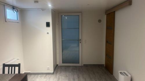 une pièce avec une porte vitrée et un parquet dans l'établissement Sous sol refait à neuf, à Champigny-sur-Marne