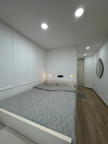 a white bedroom with a large bed in it at Studio 032 in Prčanj