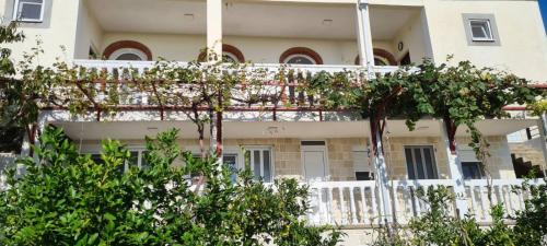 a white building with trees in front of it at Vila Pogled in Petrovac na Moru