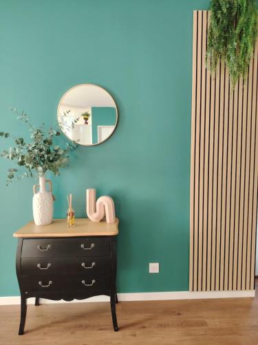 a black dresser with a mirror on a blue wall at La Tour XVIII in Sarrouilles