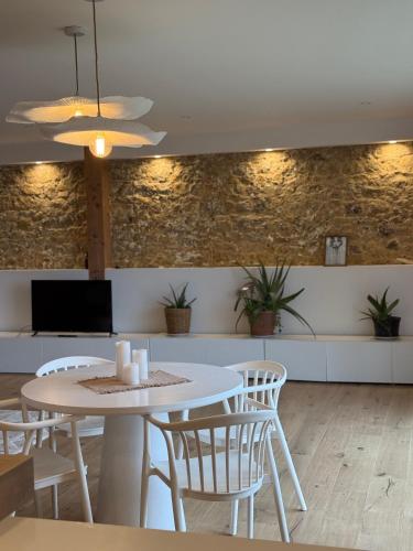 une salle à manger avec une table et des chaises blanches dans l'établissement Casa Escuela, à Plougastel-Daoulas