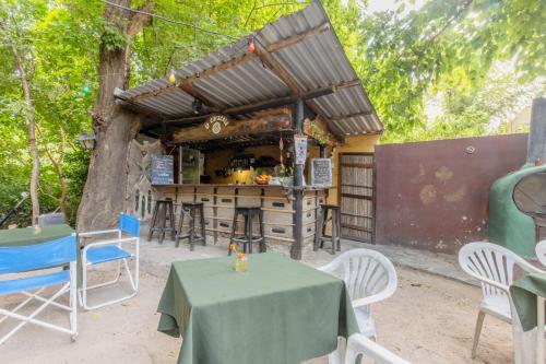 a restaurant with a table and chairs and a tree at Andamundos Hostel in Mina Clavero