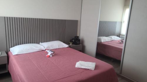a bedroom with two beds with pink sheets and towels at Casa Oddo in Marcos Juárez