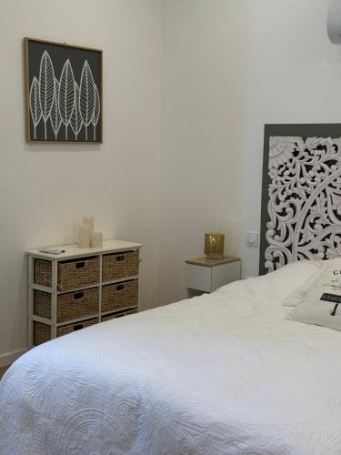 une chambre avec un lit blanc et une commode dans l'établissement Casa Escuela, à Plougastel-Daoulas