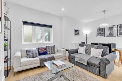 a living room with two couches and a glass table at The Coastal Den By My Getaways in Brighton & Hove