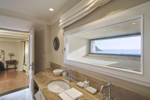 Un baño con lavabo y una gran ventana. en Villa Pedra, en Levanto