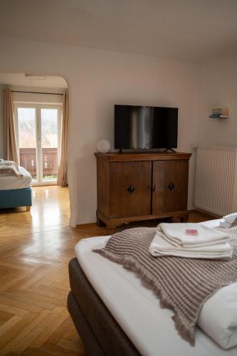 a bedroom with a bed and a tv on a dresser at WuhrsteinHaus, Heil- und Seminarzentrum Chiemgau in Schleching