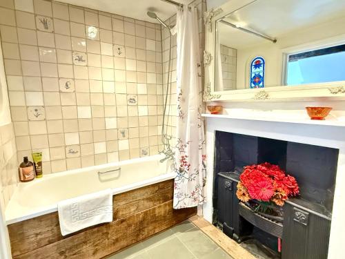 a bathroom with a fireplace and a bath tub with a fire place at Swan Cottage, 5-Bedroom, Canal View, River, Private gardens, Free Parking's, WiFi, Oxford in Kidlington