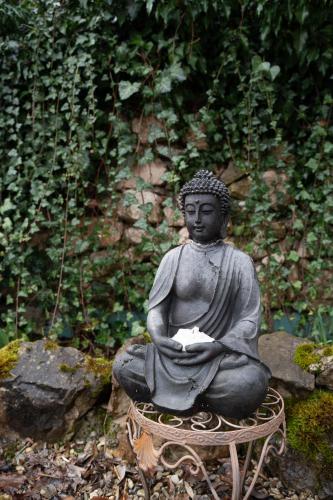 a statue of a buddha sitting on a stool at WuhrsteinHaus, Heil- und Seminarzentrum Chiemgau in Schleching