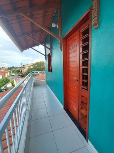a blue house with a wooden door and a balcony at House in Camocim in Camocim