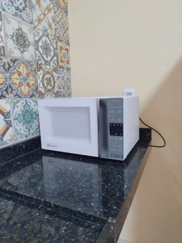 a microwave sitting on top of a counter at House in Camocim in Camocim