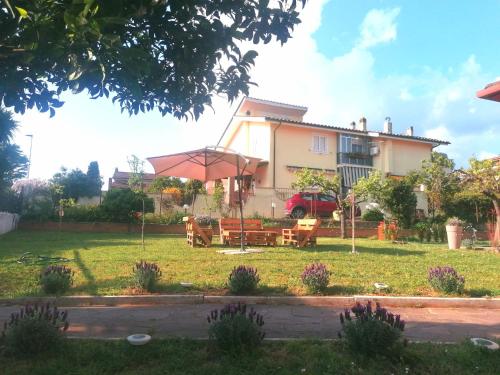 a house with a picnic table and an umbrella at Da Piero e Gina in Palidoro
