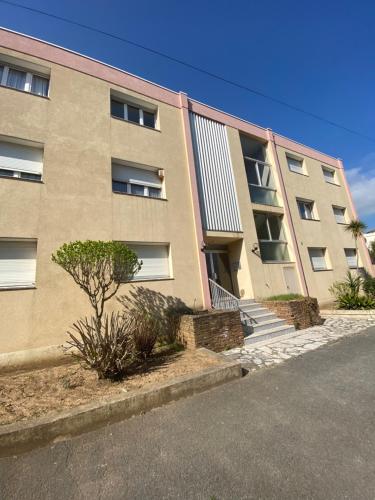 un immeuble d'appartements avec un arbre devant dans l'établissement Appartement Fréjus - T3 - 2 chambres - 5 personnes - garage - clim - port à 300 m, à Fréjus