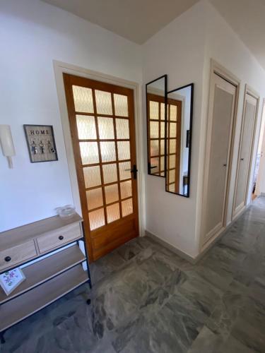 Cette chambre comprend un miroir, une commode et une porte. dans l'établissement Appartement Fréjus - T3 - 2 chambres - 5 personnes - garage - clim - port à 300 m, à Fréjus