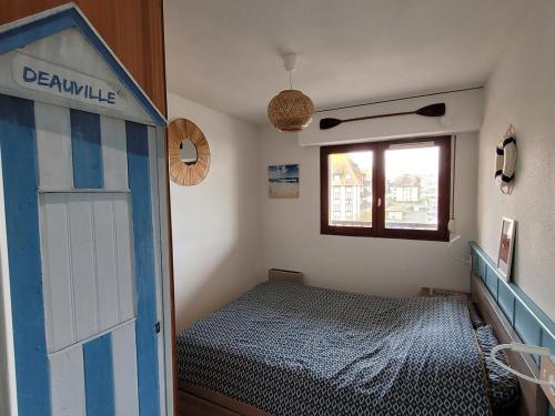 - une petite chambre avec un lit et une porte dans l'établissement La Mouette Rose, à Villers-sur-Mer