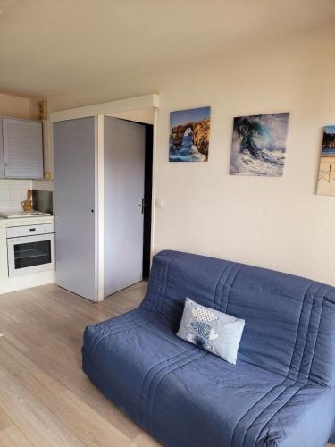 - un canapé bleu dans un salon avec une cuisine dans l'établissement La Mouette Rose, à Villers-sur-Mer