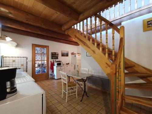 - une cuisine avec une table et un escalier dans une chambre dans l'établissement Au Bout du Monde, à Chaspinhac