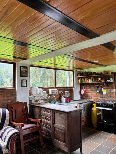 a kitchen with a wooden ceiling and a counter top at Cabaña Campestre - Ciudad Memoria in Sogamoso