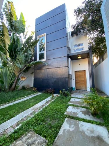 a house with a walkway in front of it at Chill Inn Hostel in Tulum