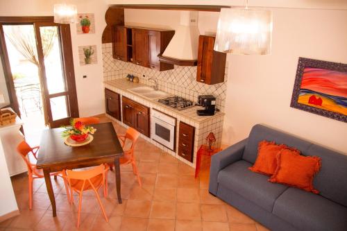 a kitchen and living room with a blue couch and a table at Anemos Apartment - Villa Luna in Macari