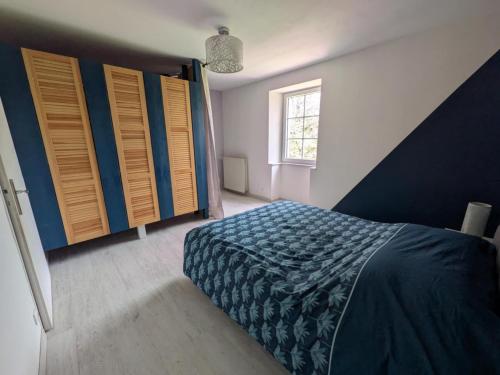 - une chambre avec un lit, des volets en bois et une fenêtre dans l'établissement À 2 pas de la forêt de la Serre, à Offlanges