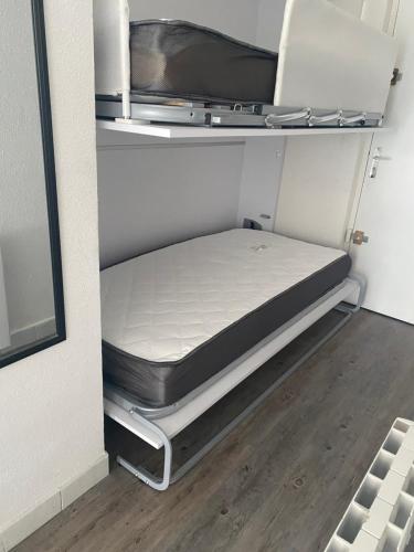 - un petit lit dans une petite chambre avec un matelas dans l'établissement Lolivier, au Grau-du-Roi