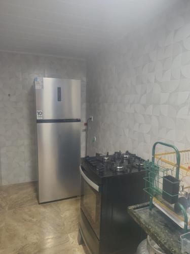 マラゴージにあるCasa pé na areiaのステンレス製の冷蔵庫とコンロを備えたキッチン