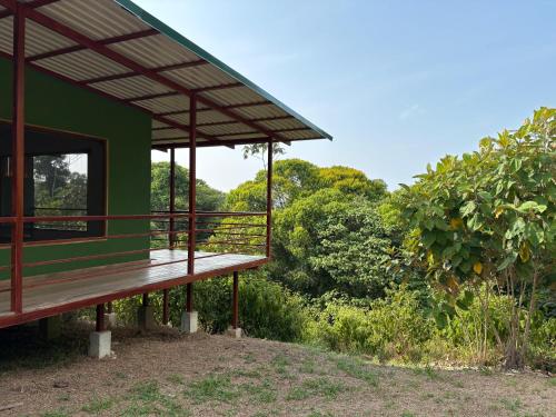 un bâtiment écologique avec une terrasse en bois à côté des arbres dans l'établissement Corcovado Tropical Garden Lodge, à Drake