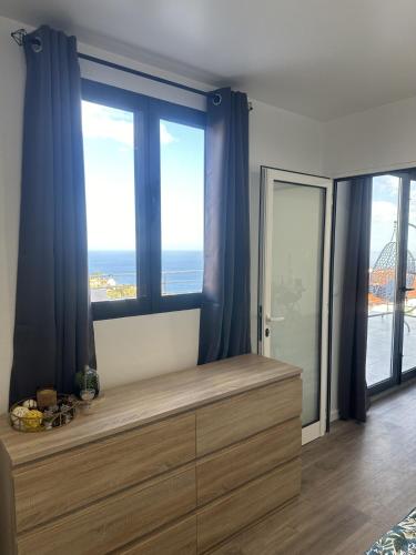 a room with a large window with the view of the ocean at Pearl Of The Sea in Ponta do Sol