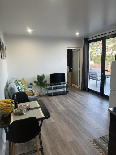 a living room with a couch and a tv at Pearl Of The Sea in Ponta do Sol