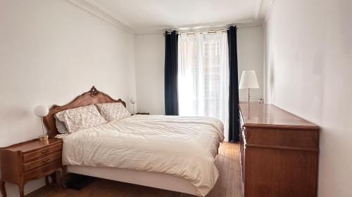 une chambre avec un lit, une commode et une fenêtre dans l'établissement Maison des Artistes, à Paris