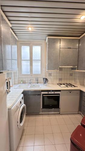 une cuisine avec un évier et un lave-vaisselle dans l'établissement Maison des Artistes, à Paris