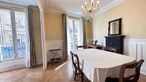 une salle à manger avec une table et un lustre dans l'établissement Maison des Artistes, à Paris