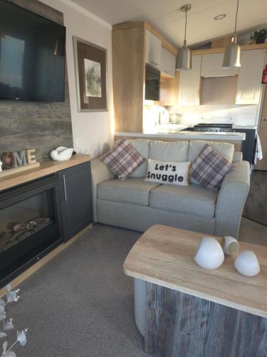a living room with a couch and a table at Silver 3 Bed Static Caravan With Patio in Port Seton