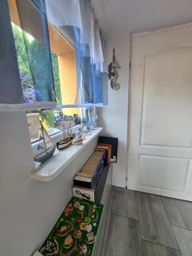 a room with a shelf with books and a window at u eli i jurka in Sztutowo