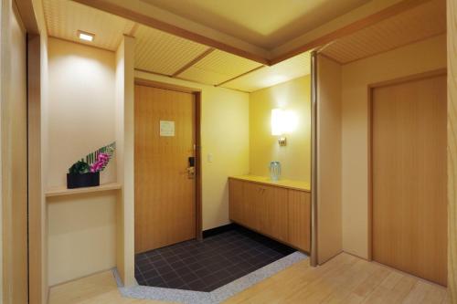 a corridor of a room with a door and a cabinet at Grand Park Otaru in Otaru