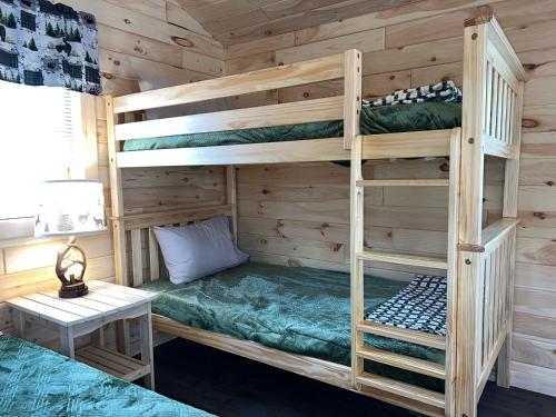 a bedroom with bunk beds in a cabin at Sister Lakes Glamping Cabin at Wonder Woods #2 in Dowagiac