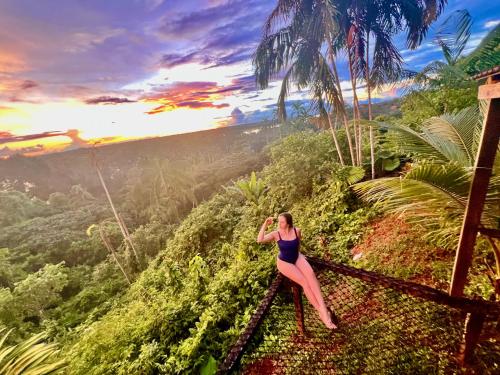 a woman sitting on a rail in the jungle at Reserva Natural Natura Park in Puerto Nariño