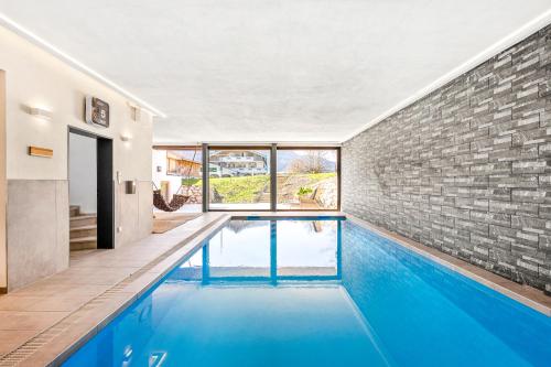 a swimming pool in a house with a brick wall at Soho Mountain Chalet - Pool und Sauna in Reit im Winkl