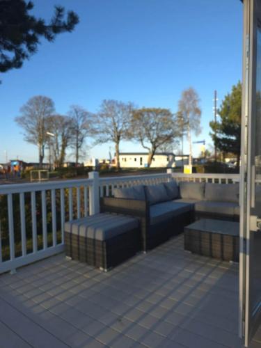 a patio with two couches on a balcony at Silver 3 Bed Static Caravan With Patio in Port Seton