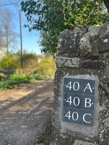 a sign on a stone wall next to a road at The Granary, Upper Largo in Kirkton of Largo