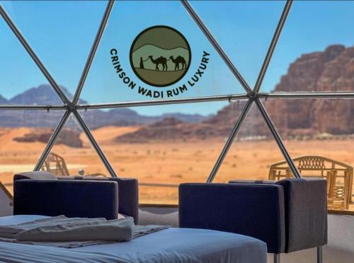 a view of the desert from a yurt with a window at Crimson wadi rum luxury in Wadi Rum