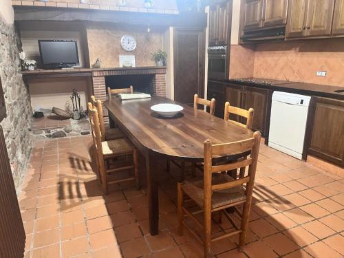 a kitchen with a wooden table and chairs at Masia Can Tibau in Llagostera