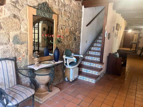 a room with a staircase and a table and chairs at Masia Can Tibau in Llagostera