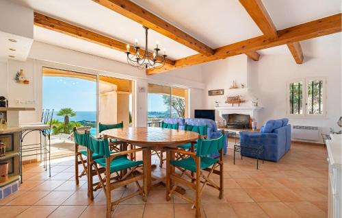 Il dispose d'une cuisine et d'un salon avec une table et des chaises en bois. dans l'établissement Mas Des Oliviers, à Cavalaire-sur-Mer