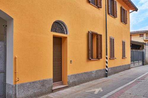 a yellow building with a door on a street at Agriturismo La Corte di Muggiano in Baggio