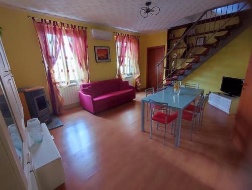 a living room with a table and a purple couch at Serra's House in Serra San Bruno